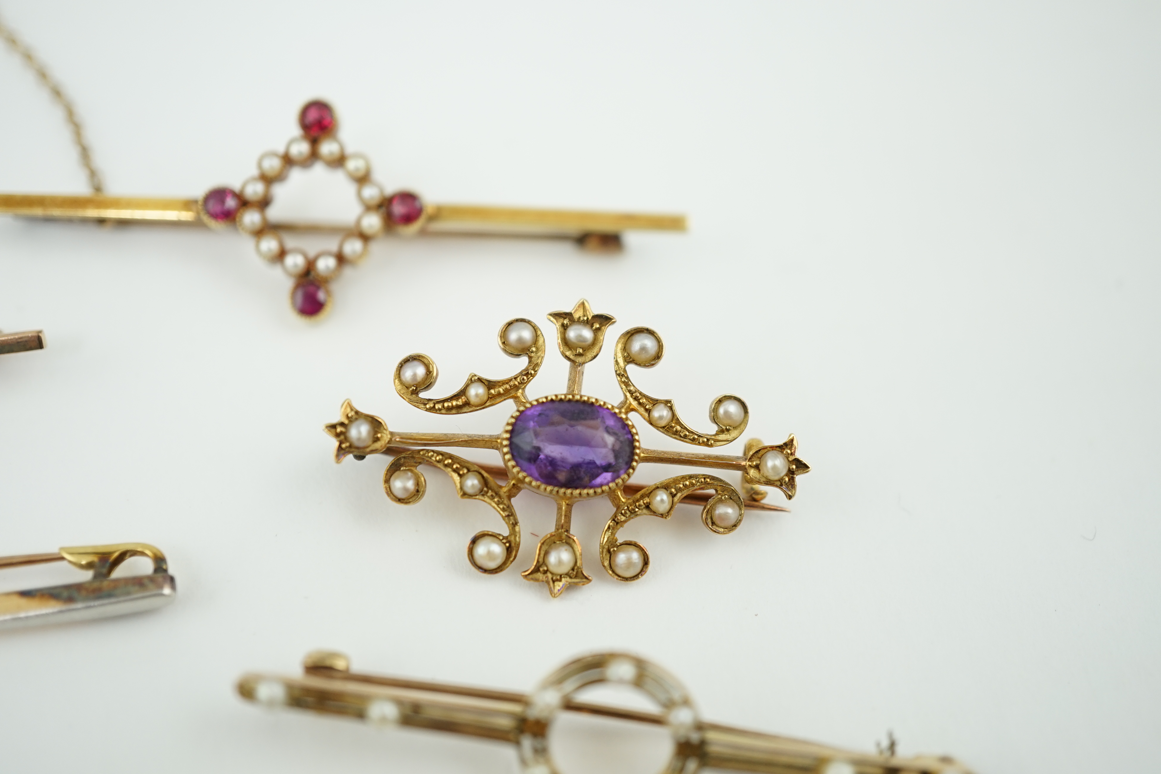 Five assorted Edwardian bar brooches, including a 15ct gold sapphire and diamond set three stone, a diamond and seed pearl, ruby? and seed pearl, a solitaire diamond set and a seed pearl and citrine bug brooch